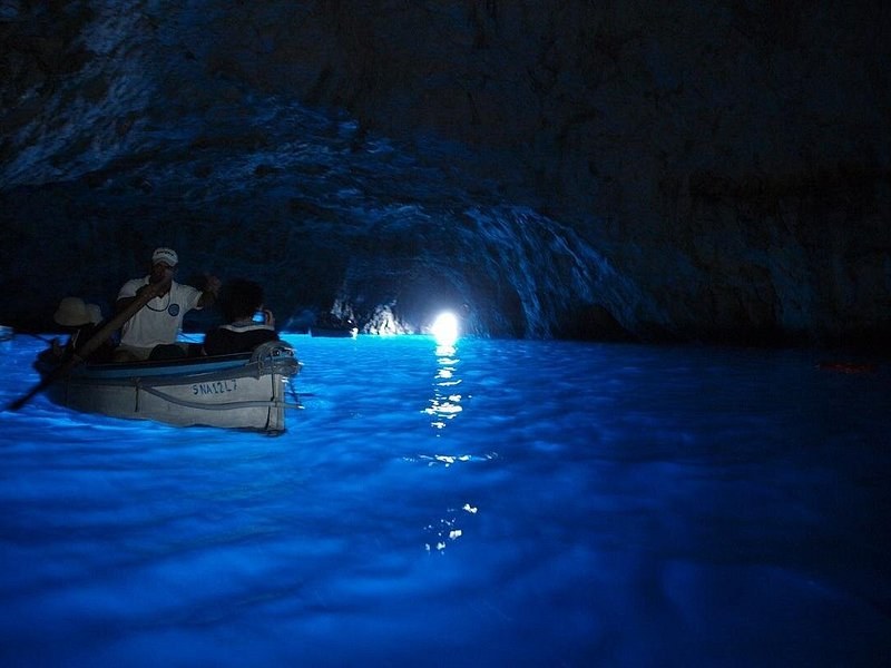 A rowboat inside the Blue Grotto on Capri, the water lit blue