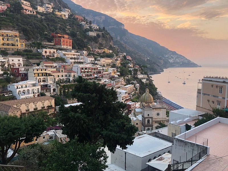 Terraces and houses of Positano at dusk, the coast running west