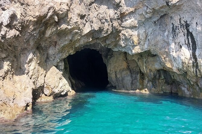 A sea cave at the waterline, turquoise water inside